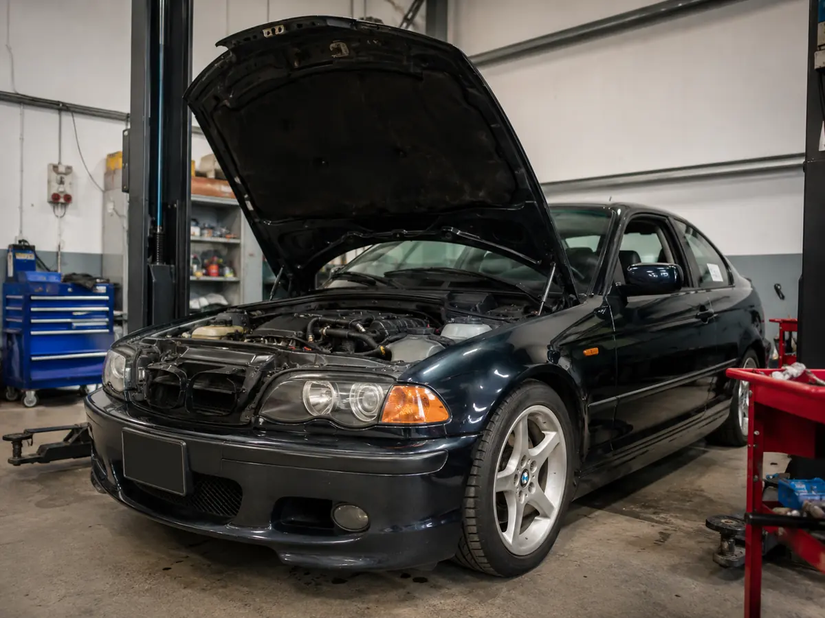 BMW in a workshop with its bonnet open for mechanical work
